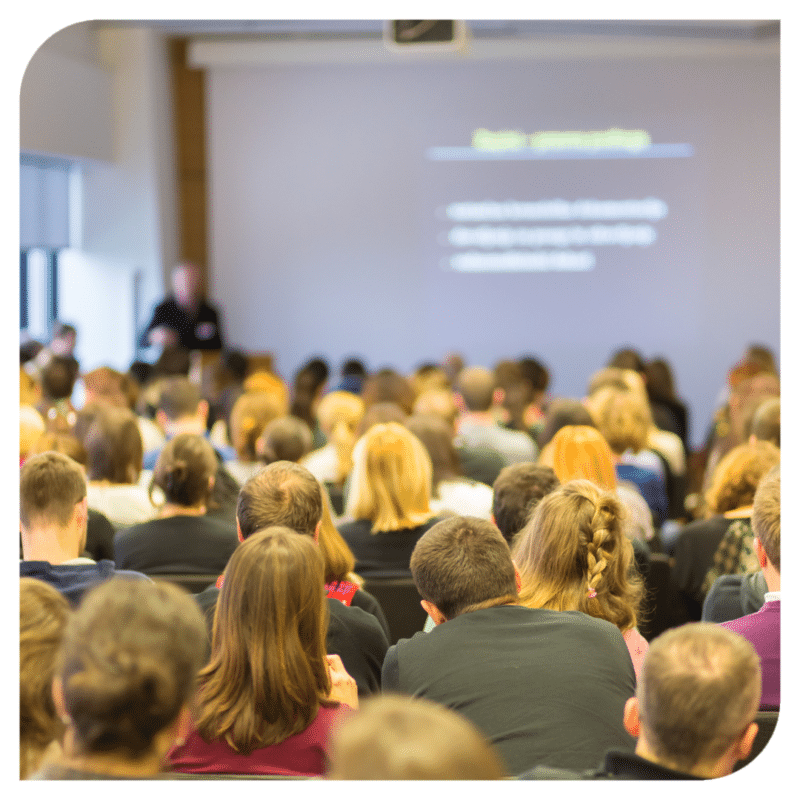 Group of people sat attending a conference.