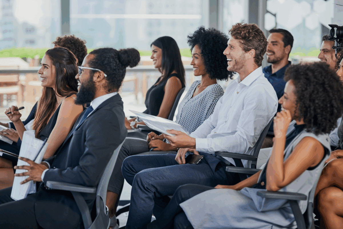 Group of colleagues listening to a presentation sitting in rows