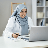 Woman working in a hospital setting looking at a laptop screen