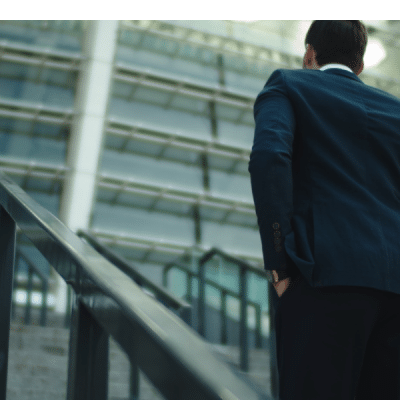 Man in suit walking up steps to a stadium