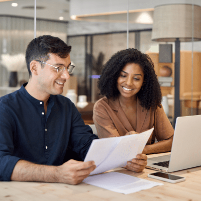 Apprentice and manager smiling together working in an office setting