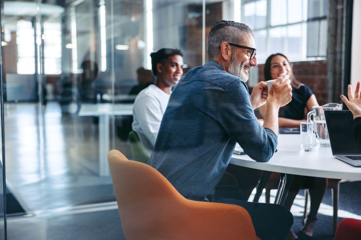 Man sat at table holding coffee cup